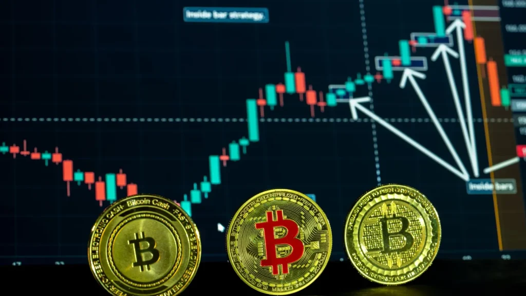 Bitcoins frente a un gráfico de negociación de criptomonedas