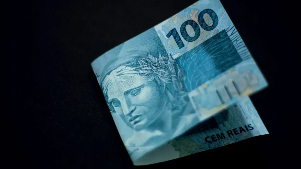 Billete de cien reales brasileños sobre fondo oscuro