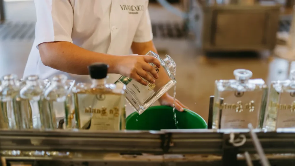Botellas de bebidas siendo llenadas en una destilería