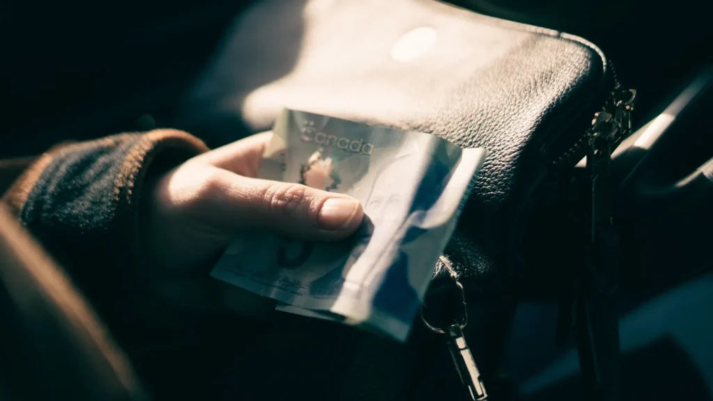 Billete canadiense sostenido por una persona